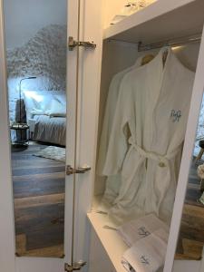 奥斯图尼Panta Rei的衣柜配有白色长袍和1张床