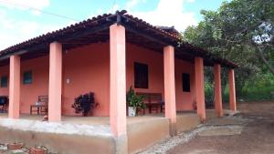 伊比科阿拉Hospedagem Flor de Araca的前面有两长椅的红色房子