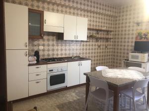 伊索拉迪卡波里祖托B & B Patrizia的一间厨房,配有白色家电和桌椅
