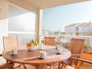 阿尔考斯布里Marineu Alcocebre Apartamentos Serena Mar的阳台上的木桌和一碗水果