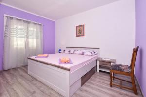 马卡尔斯卡Apartments Makarska Gudelj Cvitan的卧室配有一张白色大床和椅子