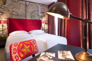 巴黎大陆酒店的一间卧室配有一张床和一张带台灯的桌子