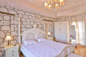 阿拉恰特爱韩酒店 - 特殊类别的卧室配有白色的床和石墙