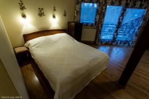 久洛格勒尼巴拉兹斯扎罗公寓的一间卧室配有一张带白色床单的床和一扇窗户。