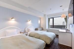 神户神户三宫联盟酒店的配有窗户的酒店客房内的两张床