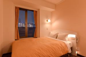 神户神户三宫联盟酒店的一间卧室设有一张大床和大窗户