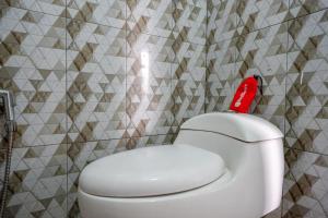 沃诺索博RedDoorz @ Gerbang Dieng Plateau Area的浴室设有白色卫生间和红色座椅。
