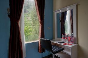 沃诺索博RedDoorz @ Gerbang Dieng Plateau Area的一张带镜子的桌子和靠窗的椅子