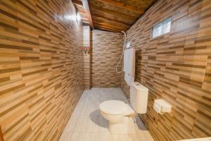 珀尼达岛Hotra Hill Cottage的一间带卫生间和木墙的浴室