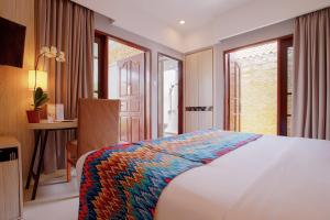 圣吉吉阿鲁娜圣吉吉会议度假酒店的卧室配有一张床、一张书桌和窗户。