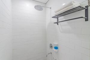 万隆RedDoorz Premium @ Hotel Hebat的带淋浴和盥洗盆的白色浴室