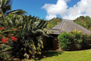 帕佩托艾Villa Anuanua by Tahiti Homes的前面有棕榈树的房子