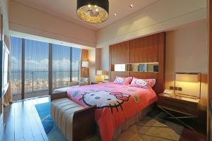 厦门厦门国际会议中心酒店的一间卧室配有一张大床和粉红色的床罩