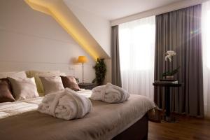 布鲁塞尔阿尔特德赛约住宿加早餐旅馆的卧室配有带毛巾的窗户。