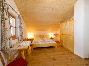 HüttschlagAlmliesl HUET-484的小房间设有床铺和木制天花板