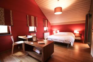 斯普里蒙L'Impasse de Lincé的一间卧室设有红色的墙壁、一张床和一张书桌