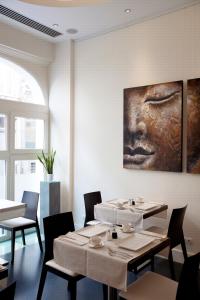 布鲁塞尔阿尔特德赛约住宿加早餐旅馆的一间设有桌子的用餐室和墙上的绘画