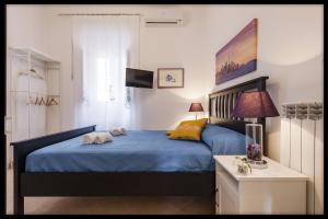阿沃拉B&B Zanzibar - Ospitalità Siciliana的一间卧室配有一张带蓝色床单和黄色枕头的床。