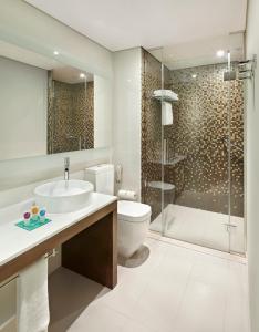 迪拜Hyatt Place Dubai Al Rigga Residences的浴室配有卫生间水槽和淋浴。