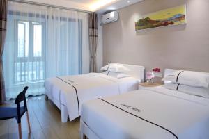 海口克拉尔绿邸酒店(免费24小时美兰机场/动车接送)的酒店客房设有两张床和窗户。