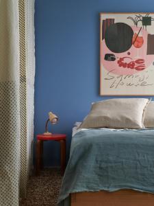 赫尔辛基Noli Sörnäinen的蓝色卧室,配有床和红色桌子