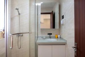 海口克拉尔绿邸酒店(免费24小时美兰机场/动车接送)的带淋浴、水槽和镜子的浴室