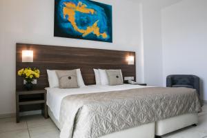 帕福斯Theo Sunset Bay Hotel的一间卧室配有一张大床和木制床头板