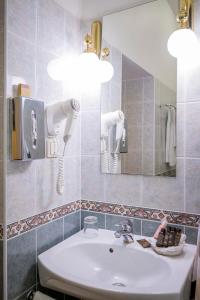 里加古腾堡酒店的一间带水槽和镜子的浴室