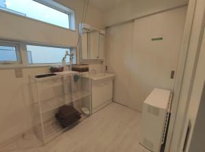 富良野Private House Naturwald的一间白色的小浴室,配有水槽和窗户