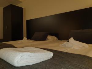 利丁厄阿里斯顿酒店的一间卧室配有两张带白色床单的床