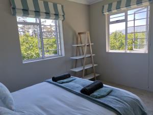 埃尔金Moortop Cottages的一间卧室设有一张床、两个窗户和梯子