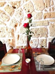 韦列Suite Sant'Irene的一张桌子,上面有板子和一个花瓶,上面有玫瑰花