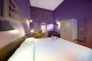 罗马Ripetta 25 Prestige Rooms的卧室配有白色的床和紫色的墙壁