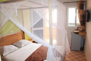 索蒙Africa 6 Plage的一间卧室配有一张带蚊帐的床
