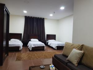 安曼Siveen Hotel的一间带两张床和一张沙发的客厅