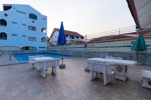 华欣瑟普莱海滩酒店的游泳池旁带桌子和遮阳伞的天井