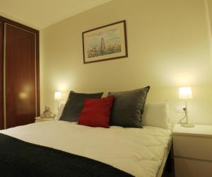 巴塞罗那阿尔格拉工业酒店式公寓的一间卧室配有一张红色枕头的床