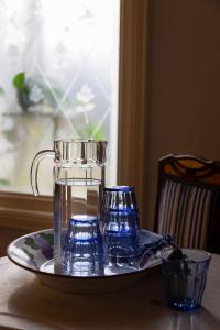 特拉萨特拉萨1900住宿加早餐旅馆的桌上的玻璃投手和两杯盘子