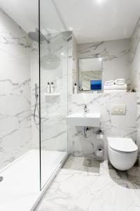 阿伯丁棕榈阁酒店的带淋浴、卫生间和盥洗盆的白色浴室