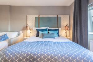 阿伯丁棕榈阁酒店的一间卧室配有一张带蓝色枕头的大床