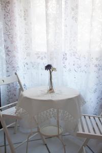 托雷安农齐亚塔Poly's House的一张桌子,花瓶和两把椅子