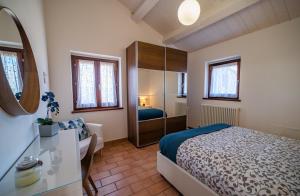 乌尔比诺Country House Ca' Brunello的一间卧室配有一张床、一张书桌和一面镜子