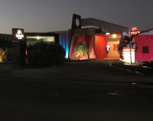 阿拉皮拉卡Lotu's Motel的享有带 ⁇ 虹灯的建筑的夜景