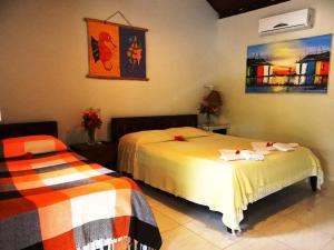 皮帕卡瓦罗马里尼奥旅馆的一间卧室设有两张床,墙上挂着一幅画