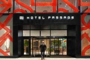 布尔诺Hotel Passage的走出酒店入口的男子