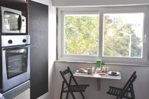 卡斯卡伊斯Cascais Family & Friends的厨房配有桌椅和窗户。