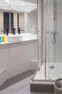 尼斯梅耶皮尔沙滩酒店的一间带玻璃淋浴和水槽的浴室