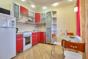 托木斯克ОК! Никитина, 20 №2的一间厨房,里面装有红色橱柜和一张桌子