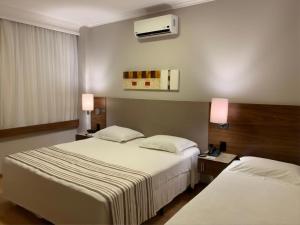 隆德里纳波旁隆德里纳商务酒店的酒店客房设有两张床和两盏灯。