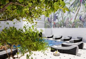 赫索尼索斯Vasia Boulevard Hotel (Adults Only)的庭院设有游泳池、椅子和树木